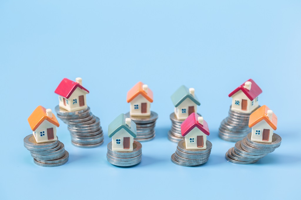 Image showing eight minature houses on a stack of coins
